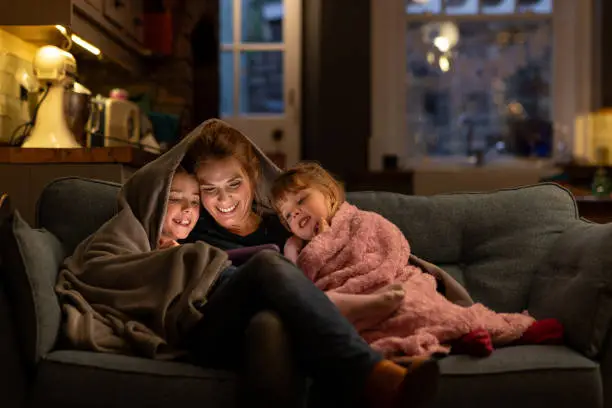 mother and her 2 children sitting on a couch